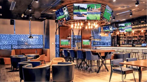 A restaurant with multiple displays and in-ceiling speakers. 