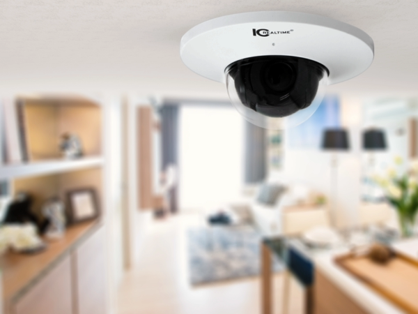 An IC Realtime outdoor security camera is mounted near a tranquil pond surrounded by trees, monitoring the natural landscape.