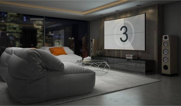 Modern media room with a large projection screen, surround sound speakers, and comfortable lounge seating.