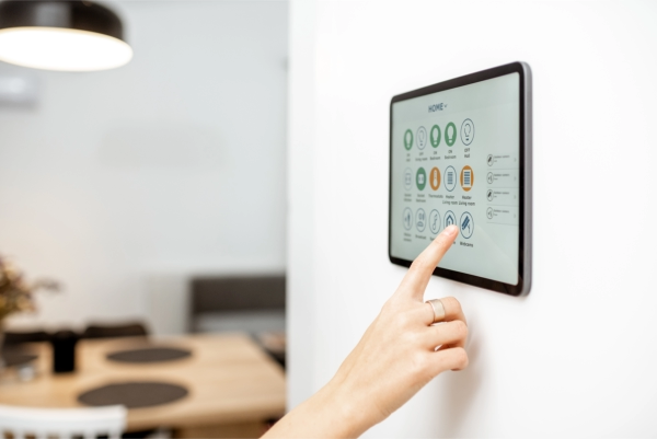Woman uses her ipad to control her smart home, including lights, cameras, and shades